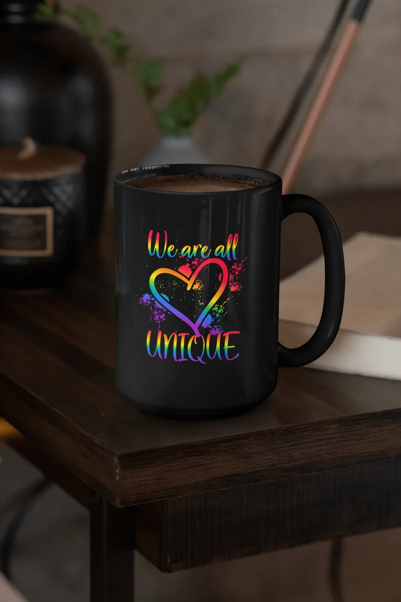 Black coffee mug with a rainbow heart and the text We are all unique