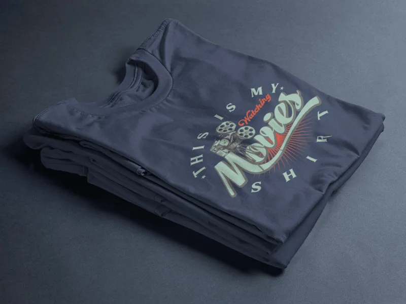 Stack of navy blue t-shirts with a vintage-style graphic reading This is my watching movies shirt